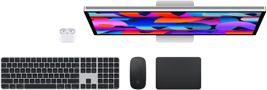 Imagem de cima dos acessórios para Mac: Studio Display, AirPods, Magic Keyboard, Magic Mouse e Magic Trackpad.