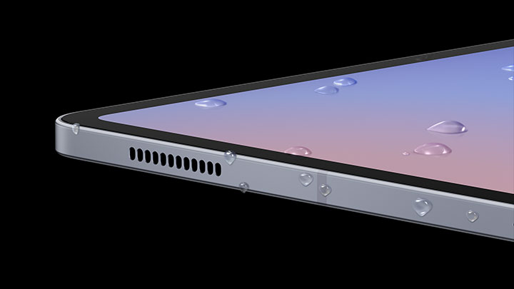 Uma imagem de perto da tela do dispositivo Galaxy Tab S10 Series mostra gotas de água espalhadas pelo display e nas laterais. A tela está ligada, exibindo um papel de parede e destacando a resistência à água do dispositivo.