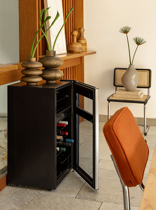 Mini bar preto com duas garrafas de vinho e vasos decorativos ao lado.